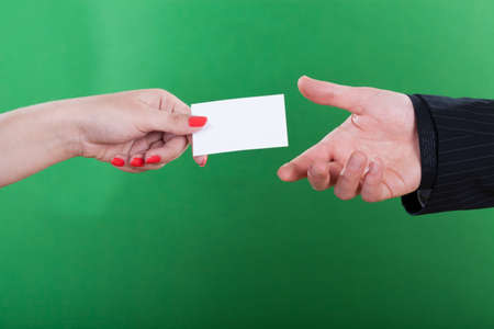 Close-up of woman giving man her business cardの写真素材