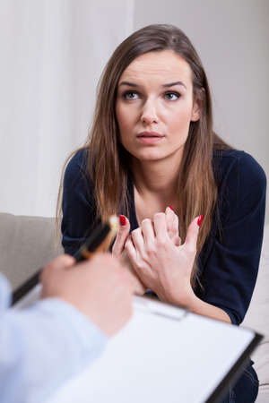Depressed woman sitting on therapy in cabinetの写真素材