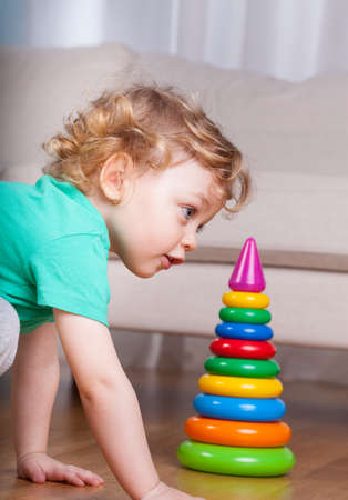 Little boy building plastic tower on the floorの写真素材