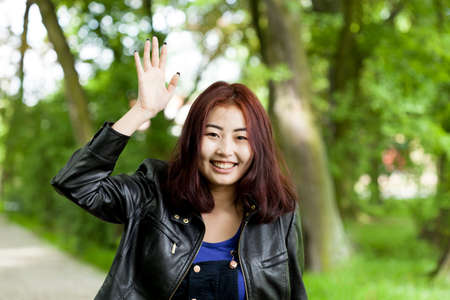 Portrait of asian girl waving her handの写真素材
