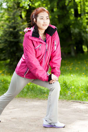 Asian girl exercising before run in the park
