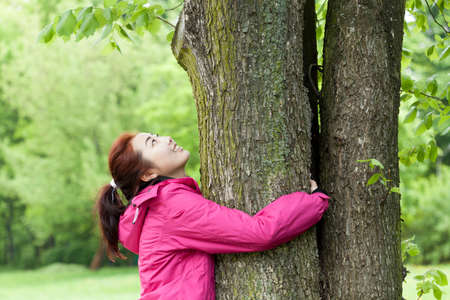 Portrait of girl hugging tree in the parkの写真素材