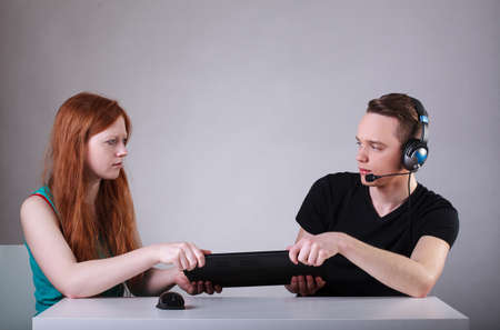 Girlfriend trying to tear computer to her boyfriendの写真素材