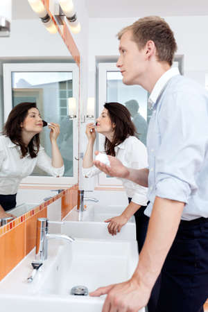 Busy couple in a bathroom in the morningの写真素材