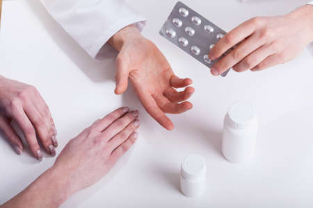 Doctor giving patient medicines closeup isolated hands photo