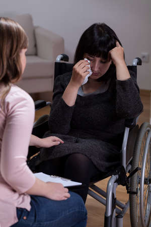 Disabled woman and her therapist at home