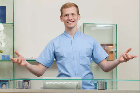 Happy male spa receptionist during work, horizontalのeditorial素材