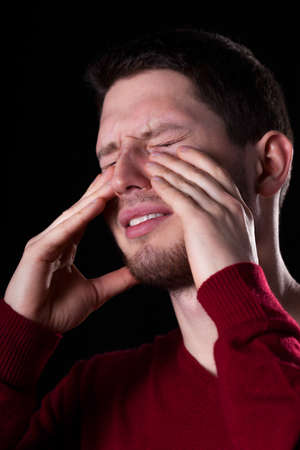 Man with sinus pain on black backgroundの写真素材