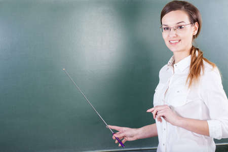Teacher working next to blackboard at schoolの写真素材