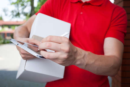 Close-up of a courier using tablet at work