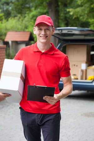 Portrait of a happy delivery man, verticalの写真素材