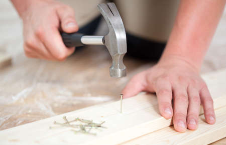 Man driving a nail during renovation, horizontalの写真素材