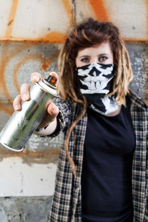 Young female hooligan holding graffiti spray in handの写真素材