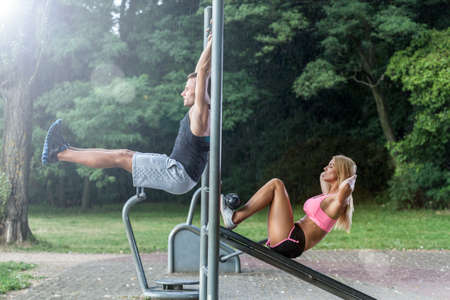 Couple working out on outdoor gym, horizontal
