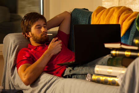 Student smoking cigarette during night before examの写真素材