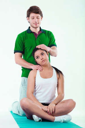 Closeup of physiotherapist helping patient with painful neckの写真素材