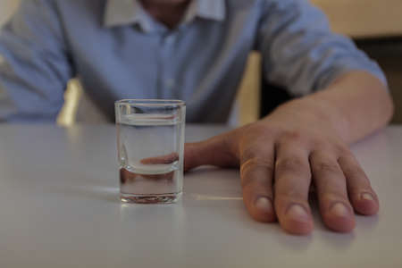 Horizontal view of struggle with vodka addictionの写真素材