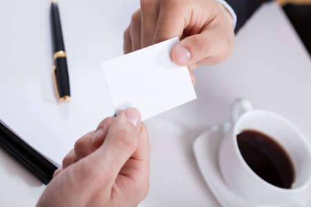 Close-up of a hands giving business cardの写真素材