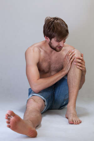 Man with a pain in knee, verticalの写真素材