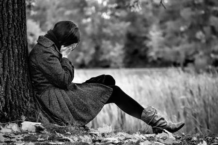 An image of desperate women in autumn parkの写真素材