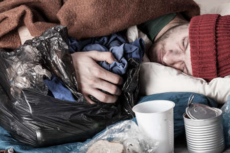 Homeless young man sleeping on the streetの写真素材