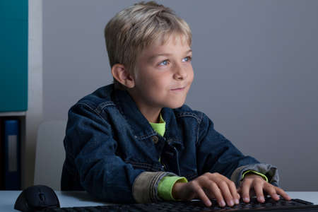 Boy playing on computer at night, horizontal