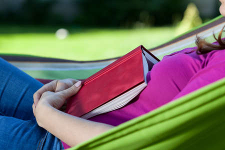 Young woman fell asleep with book on hammock の写真素材