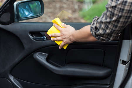 Man cleaning door in a car, horizontalの写真素材