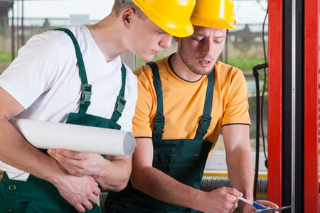 Teamwork of two professional factory engineers, horizontal