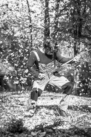 A gardener playing a rake guitar in black and whiteの写真素材