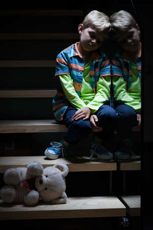 View of lonely little boy on stairsの写真素材