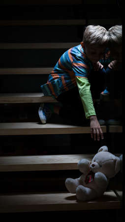 View of boy on stairs at nightの写真素材