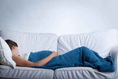 Horizonal view of a sleeping pregnant womanの写真素材