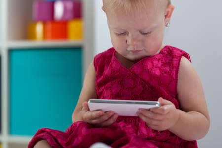 Horizontal view of little girl holding smartphoneの写真素材