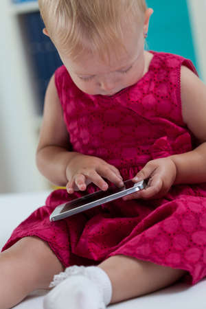 Vertical view of little girl with smartphoneの写真素材