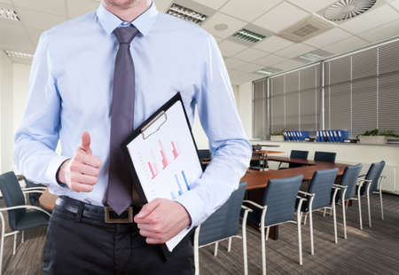 Businessman standing in boardroom with briefcase