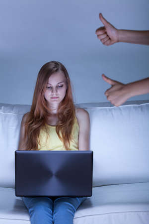a girl sitting on sofa and using notebookの写真素材
