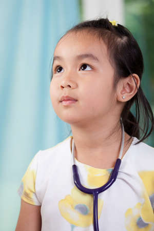 Little asian girl as a doctor, verticalの写真素材