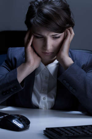 Depressing businesswoman in the office at nightの写真素材