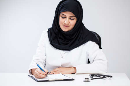 Arab female doctor noting in her officeの写真素材