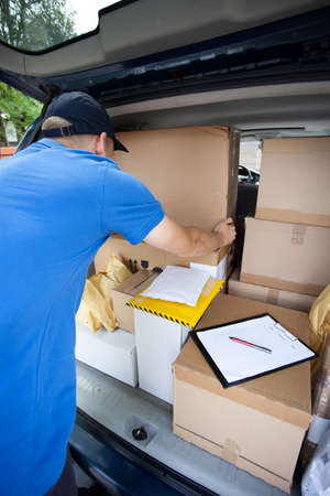 Delivery guy sorting through packages in his van