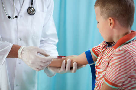 Pediatrician taking blood sample of 4 years old boyの写真素材