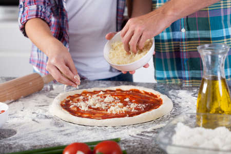 Horizontal view of pizza preparing at homeの写真素材