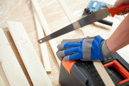 Close-up of using hand saw during house renovationの写真素材