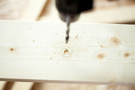 Close-up of a electric drill and wooden plankの写真素材
