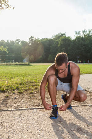 Sporting man taking rest during running in park