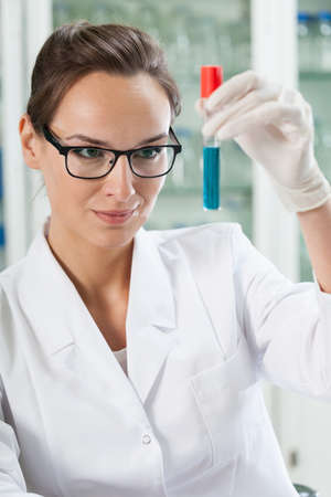 Chemist watching test tube with chemical reaction