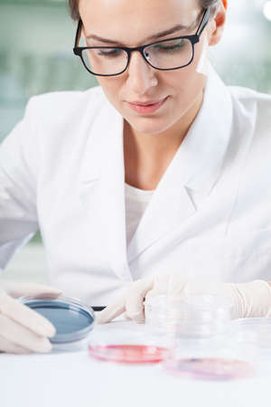 Concentrated female biologist analyzing results of research
