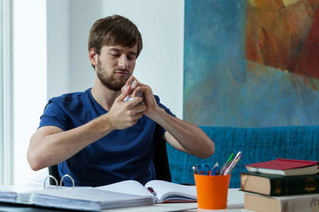 Angry student crushing paper ball during work