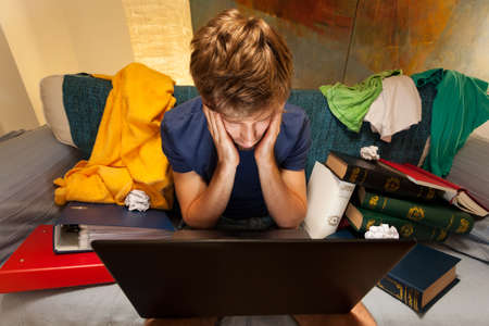 Top view of exhausted student sitting on the couch with laptopの写真素材